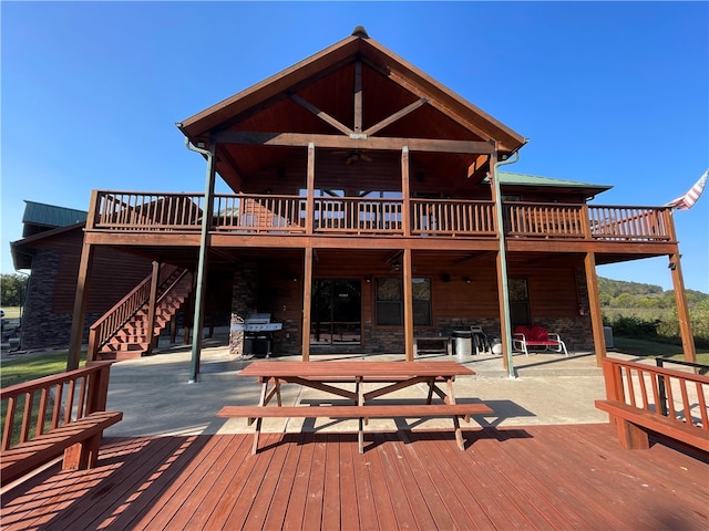 back of house featuring a wooden deck and a patio area