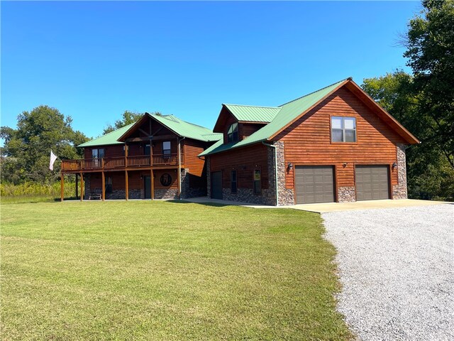 log home featuring a garage, a front yard, and a wooden deck