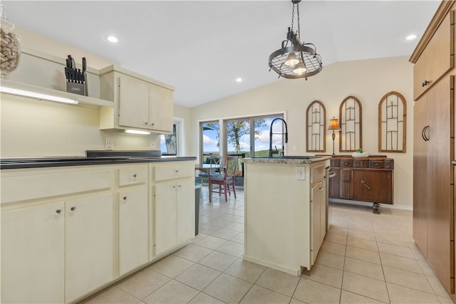 kitchen featuring pendant lighting, lofted ceiling, light tile patterned floors, cream cabinets, and a center island