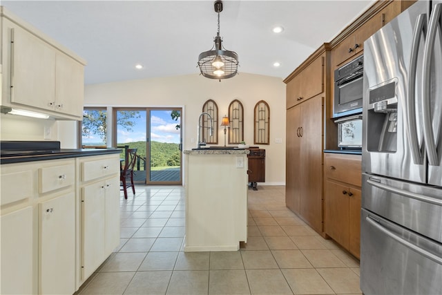 kitchen featuring pendant lighting, lofted ceiling, light tile patterned floors, cream cabinets, and appliances with stainless steel finishes