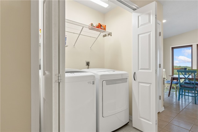 washroom with washer and dryer and light tile patterned floors