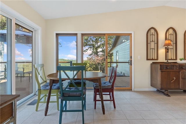 dining room featuring light tile patterned flooring, vaulted ceiling, and a wealth of natural light