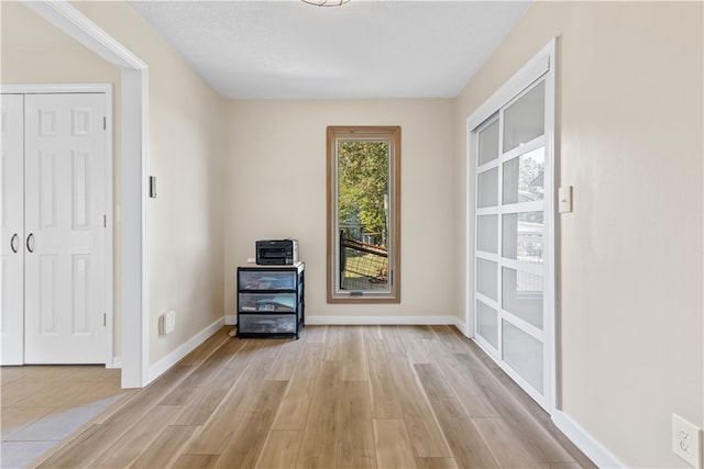 interior space featuring light hardwood / wood-style flooring and a textured ceiling