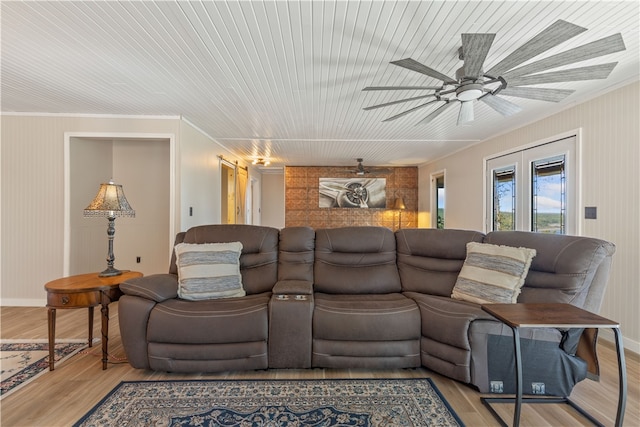 living room featuring crown molding, light wood-type flooring, and ceiling fan