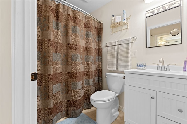 bathroom with a shower with curtain, vanity, toilet, and tile patterned floors