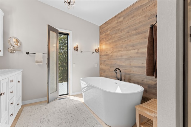 bathroom with vanity, a bathtub, wood walls, and tile patterned flooring