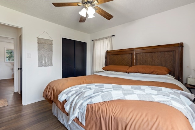 bedroom featuring dark hardwood / wood-style flooring, a textured ceiling, and ceiling fan