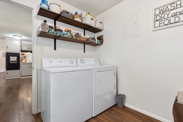 laundry room with electric panel, washer and clothes dryer, dark hardwood / wood-style floors, and a textured ceiling