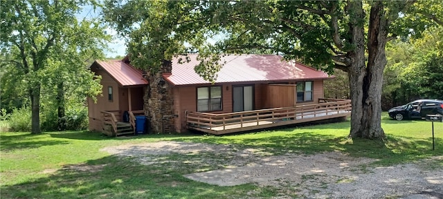 back of house with a wooden deck and a lawn