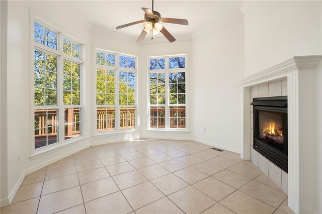 unfurnished sunroom featuring a fireplace and ceiling fan