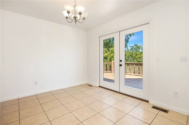 entryway with a chandelier, light tile patterned floors, and french doors