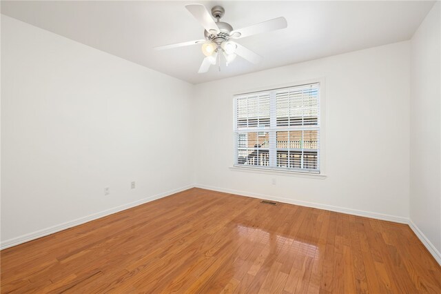 empty room with hardwood / wood-style flooring and ceiling fan