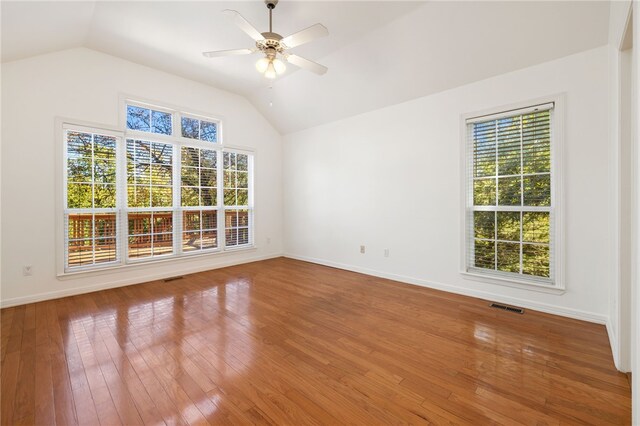 empty room featuring hardwood / wood-style floors, vaulted ceiling, and ceiling fan