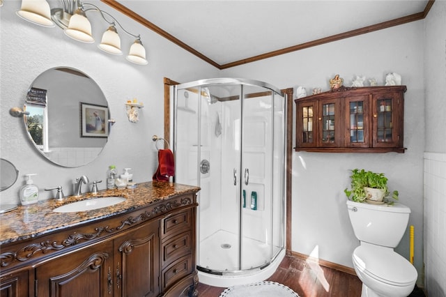 bathroom with wood-type flooring, vanity, a shower with shower door, and toilet