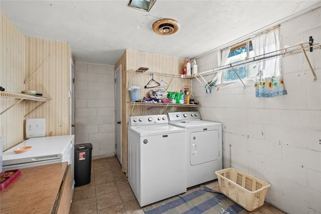 washroom with washer and dryer, light tile patterned floors, and a textured ceiling