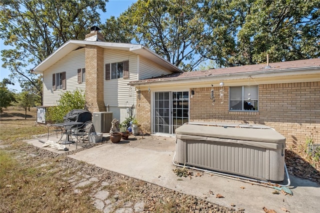 rear view of house featuring cooling unit and a patio