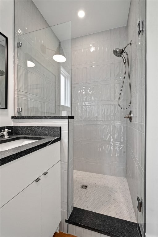 bathroom featuring walk in shower and vanity