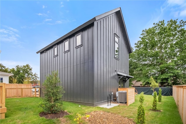 view of side of property featuring a yard and central air condition unit