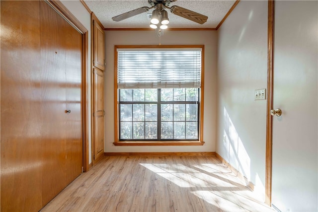 doorway to outside with ceiling fan, a textured ceiling, light wood-type flooring, and ornamental molding