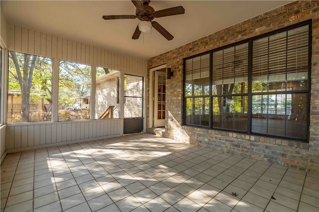 unfurnished sunroom with ceiling fan