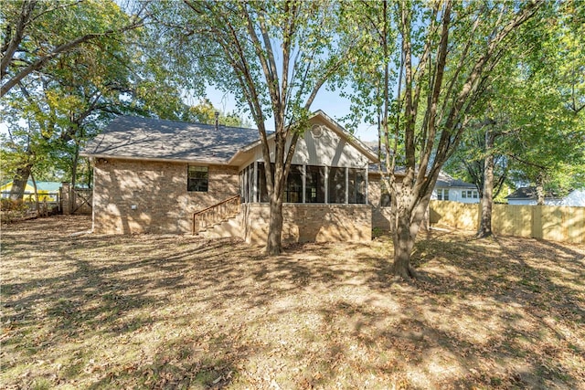 rear view of house featuring a sunroom