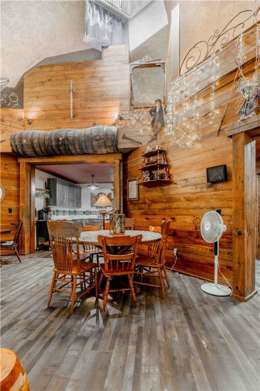 dining room featuring hardwood / wood-style flooring and wooden walls