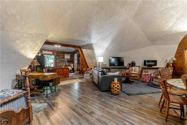 living room with hardwood / wood-style floors, a textured ceiling, and vaulted ceiling