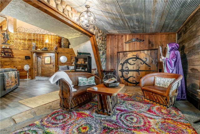 living area featuring a chandelier, lofted ceiling, wooden walls, and hardwood / wood-style flooring