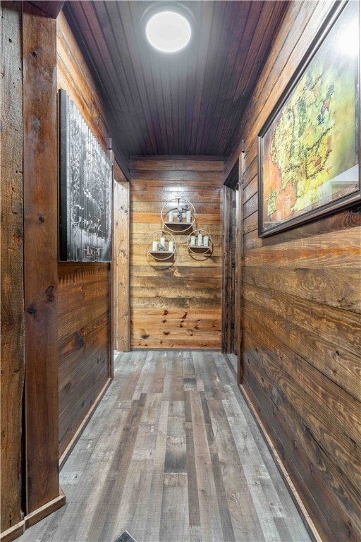 corridor featuring wood walls, wood ceiling, and hardwood / wood-style flooring