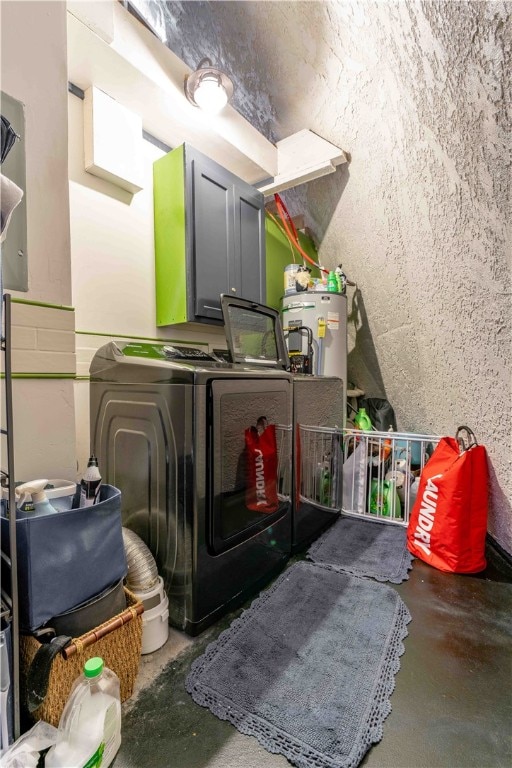 clothes washing area featuring water heater and washing machine and clothes dryer