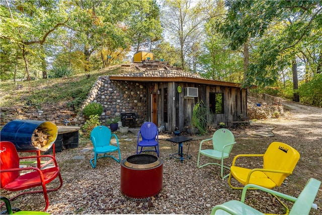 view of patio / terrace featuring an AC wall unit and a fire pit