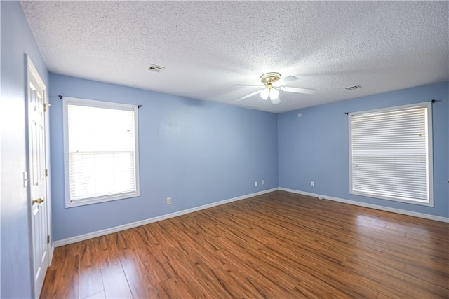 unfurnished room featuring dark wood-type flooring, ceiling fan, and a textured ceiling