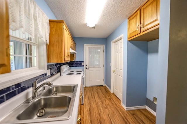 kitchen featuring light hardwood / wood-style floors, electric range, sink, backsplash, and a textured ceiling