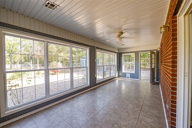 unfurnished sunroom with ceiling fan