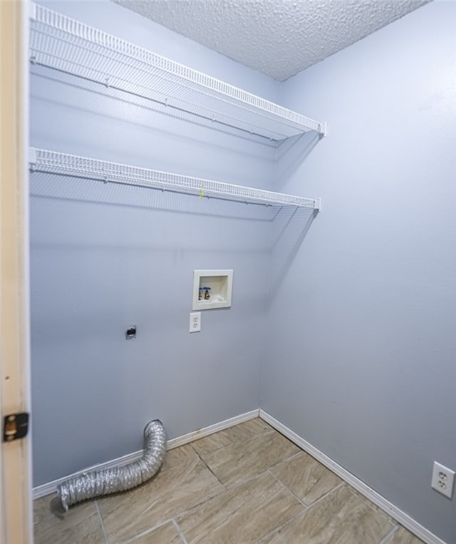 laundry area with hookup for an electric dryer, hookup for a washing machine, and a textured ceiling