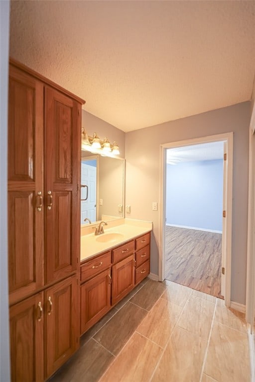 bathroom with wood-type flooring, vanity, and a textured ceiling