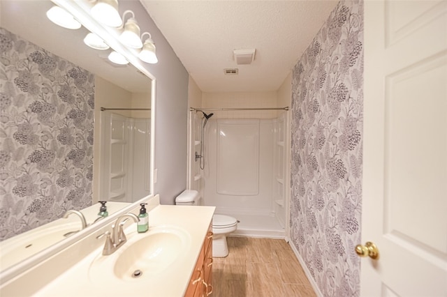 bathroom with toilet, vanity, a shower with curtain, and a textured ceiling