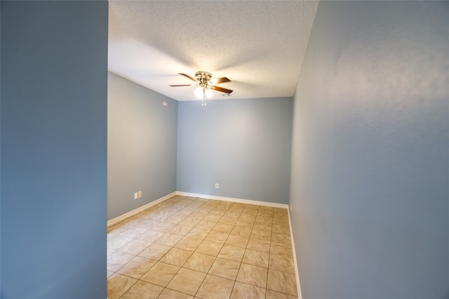 spare room with ceiling fan, a textured ceiling, and light tile patterned flooring