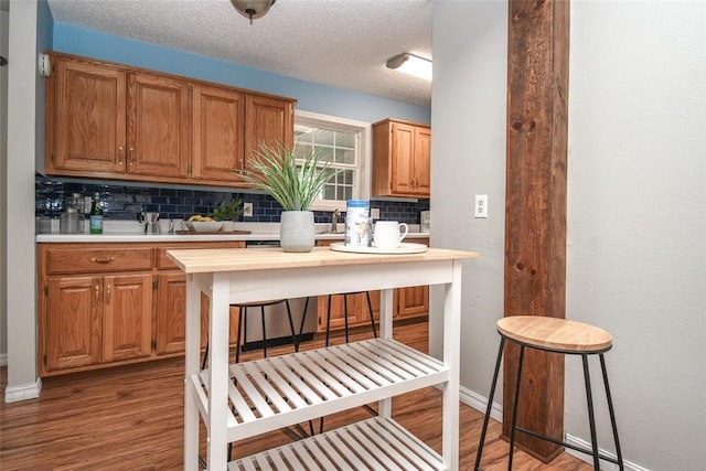 1 Hartlepool Dr, Bella Vista, AR 72715 - kitchen with tasteful backsplash, baseboards, light countertops, light wood-style floors, and a textured ceiling
