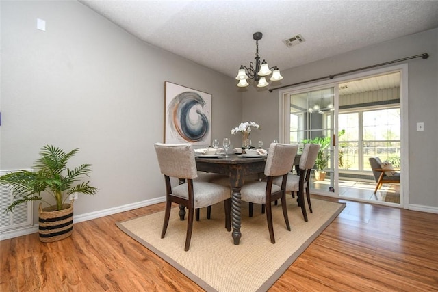 1 Hartlepool Dr, Bella Vista, AR 72715 - dining space featuring visible vents, baseboards, an inviting chandelier, and wood finished floors