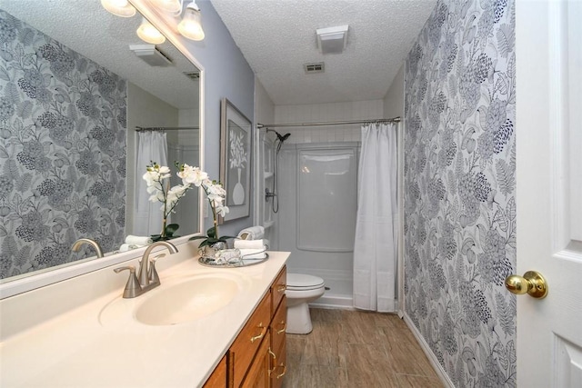 1 Hartlepool Dr, Bella Vista, AR 72715 - bathroom with vanity, a textured ceiling, toilet, visible vents, and wood finished floors
