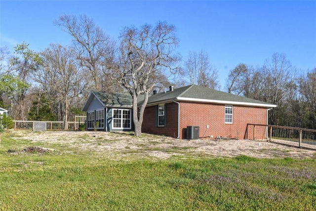 1 Hartlepool Dr, Bella Vista, AR 72715 - back of property with central air condition unit, brick siding, a sunroom, a yard, and fence
