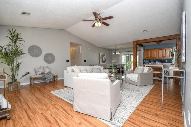 1 Hartlepool Dr, Bella Vista, AR 72715 - living room with light wood-type flooring, ceiling fan with notable chandelier, visible vents, and lofted ceiling