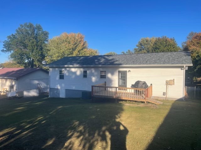 back of property with a yard and a deck