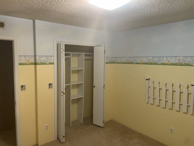 unfurnished bedroom featuring a closet and a textured ceiling