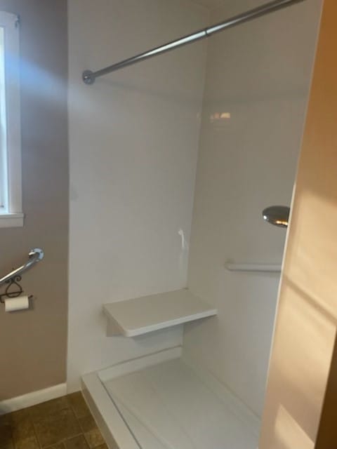 bathroom with walk in shower and baseboards