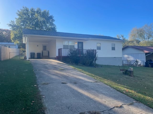 view of front facade featuring fence, a front lawn, a carport, and concrete driveway