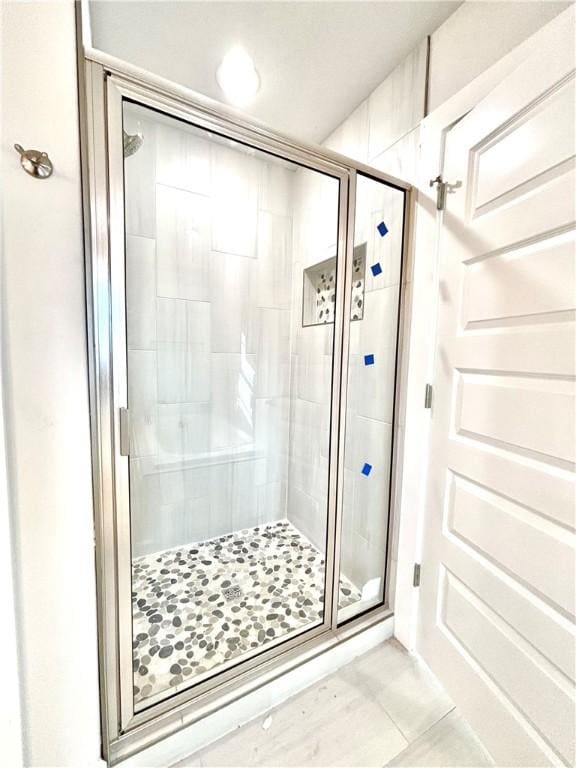 bathroom featuring tile patterned flooring and an enclosed shower