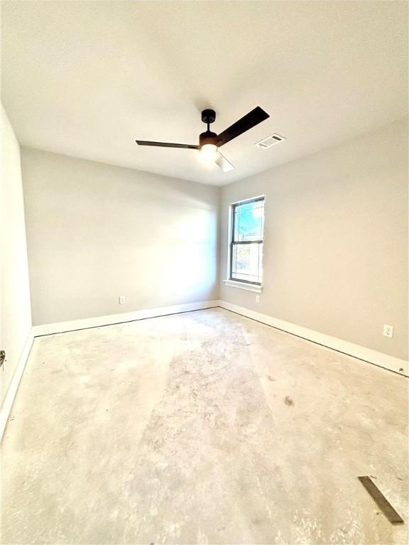 spare room with ceiling fan and concrete floors