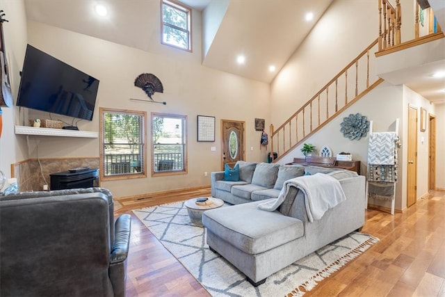 living room featuring light hardwood / wood-style flooring, plenty of natural light, and high vaulted ceiling